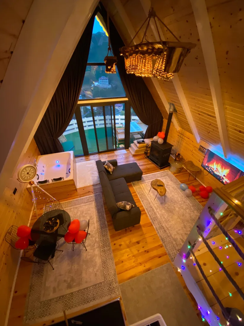 Bungalov 1 — oturma alanı, şömine ve panoramik cam cephe